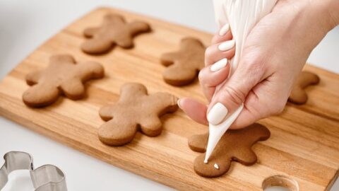 Person Decorating a Gingerbread Man Cookies