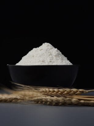 a bowl of flour sitting on top of a table